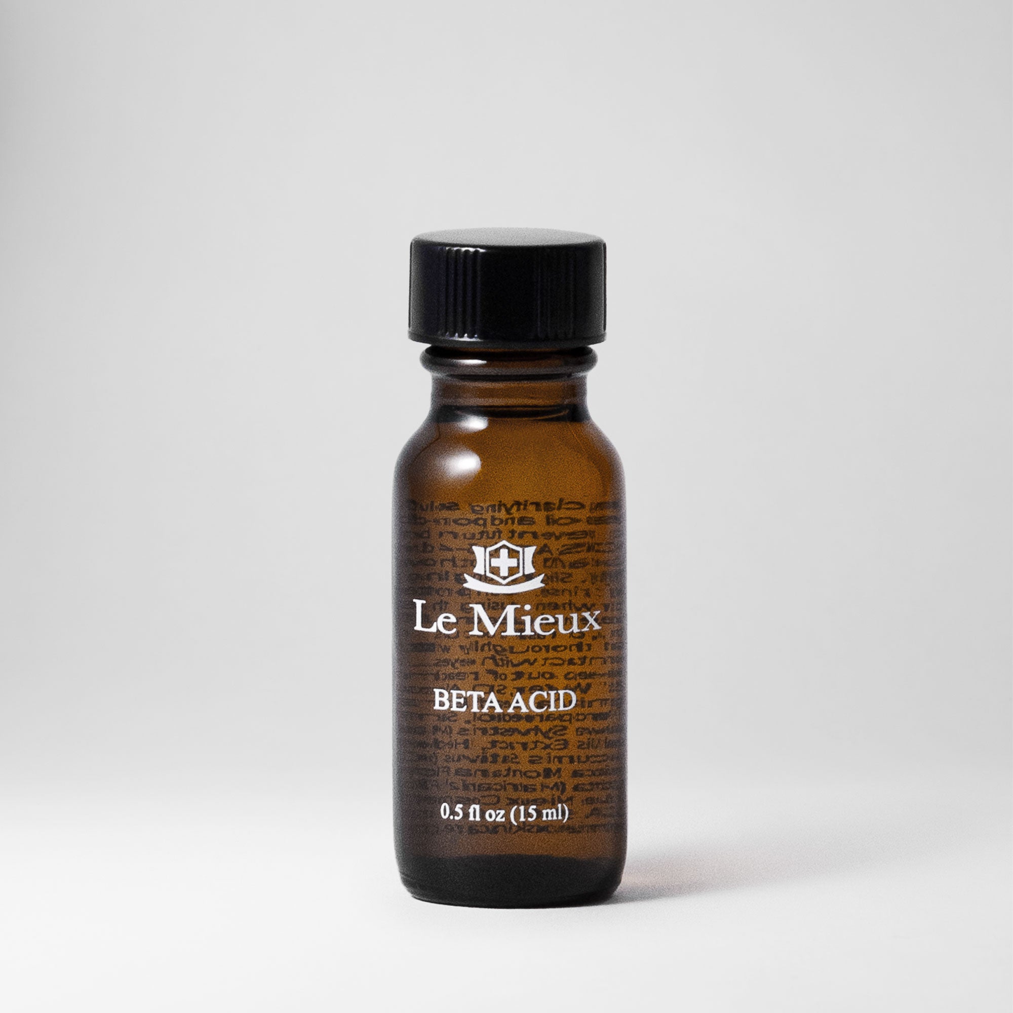Beta Acid 0.5 oz amber bottle with black lid isolated on a light grey background
